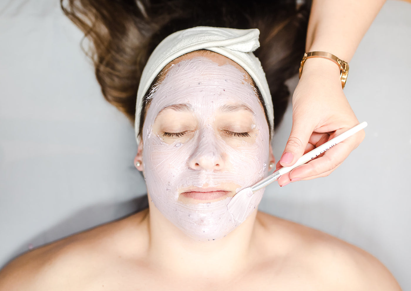 Woman in spa treatment getting an Eminence Organics face mask applied