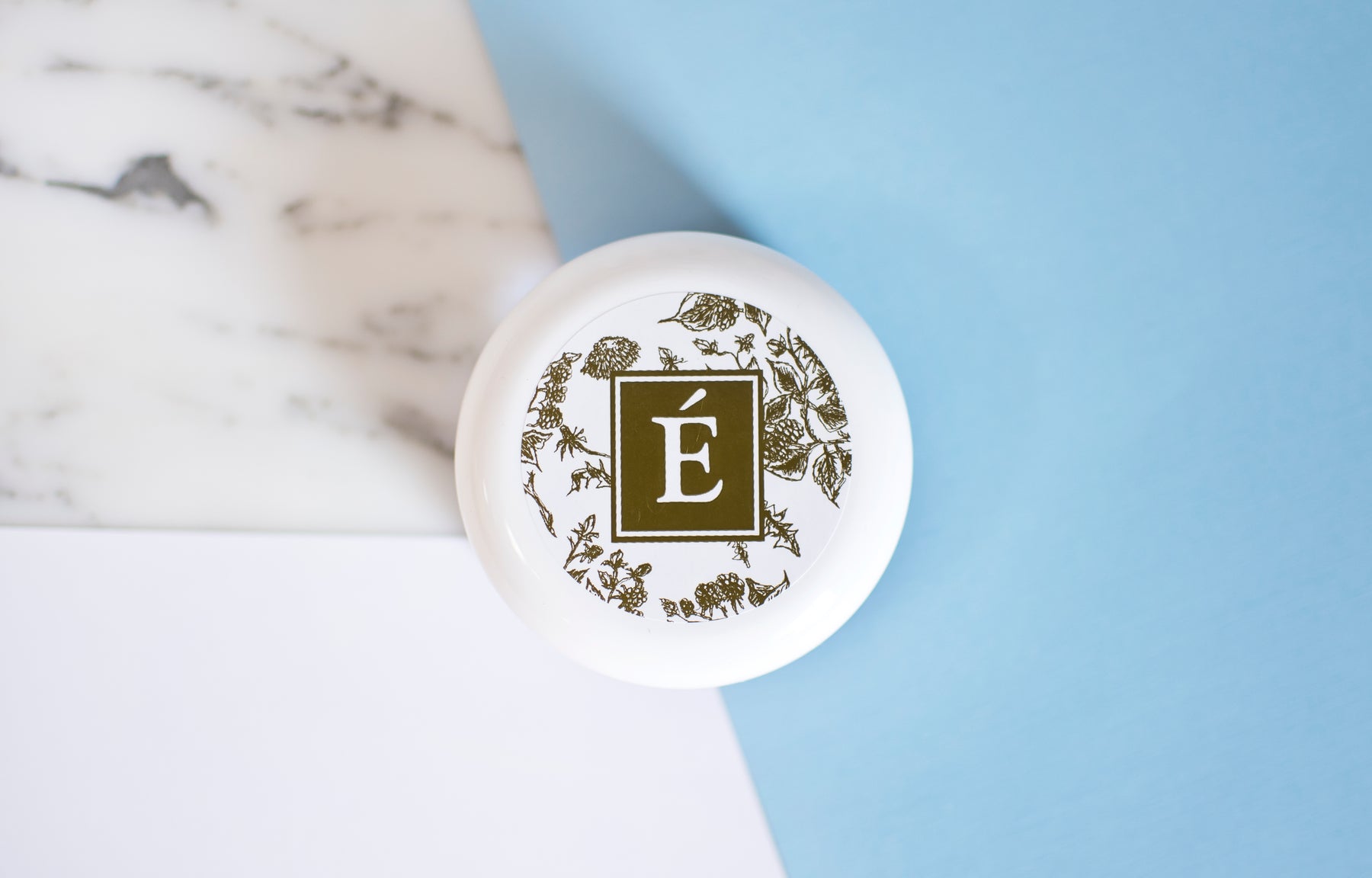 Eminence Organics moisturizer with logo on lid with white and blue background